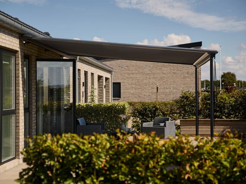 Sigma pergola med motor skaber skygge over terrasse