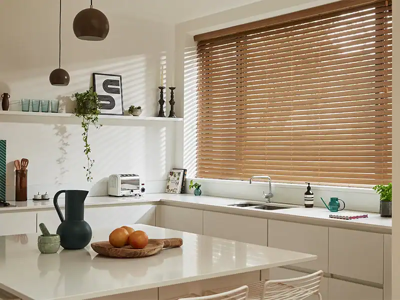 Elegant køkken med naturlige træpersienner, moderne indretning og naturligt lysindfald