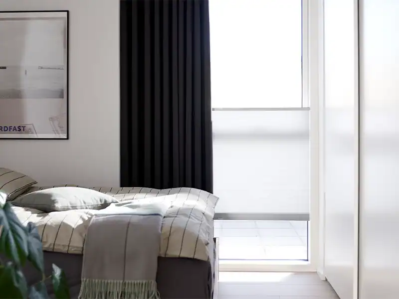 Soveværelse med mørklæggende lange stofgardiner